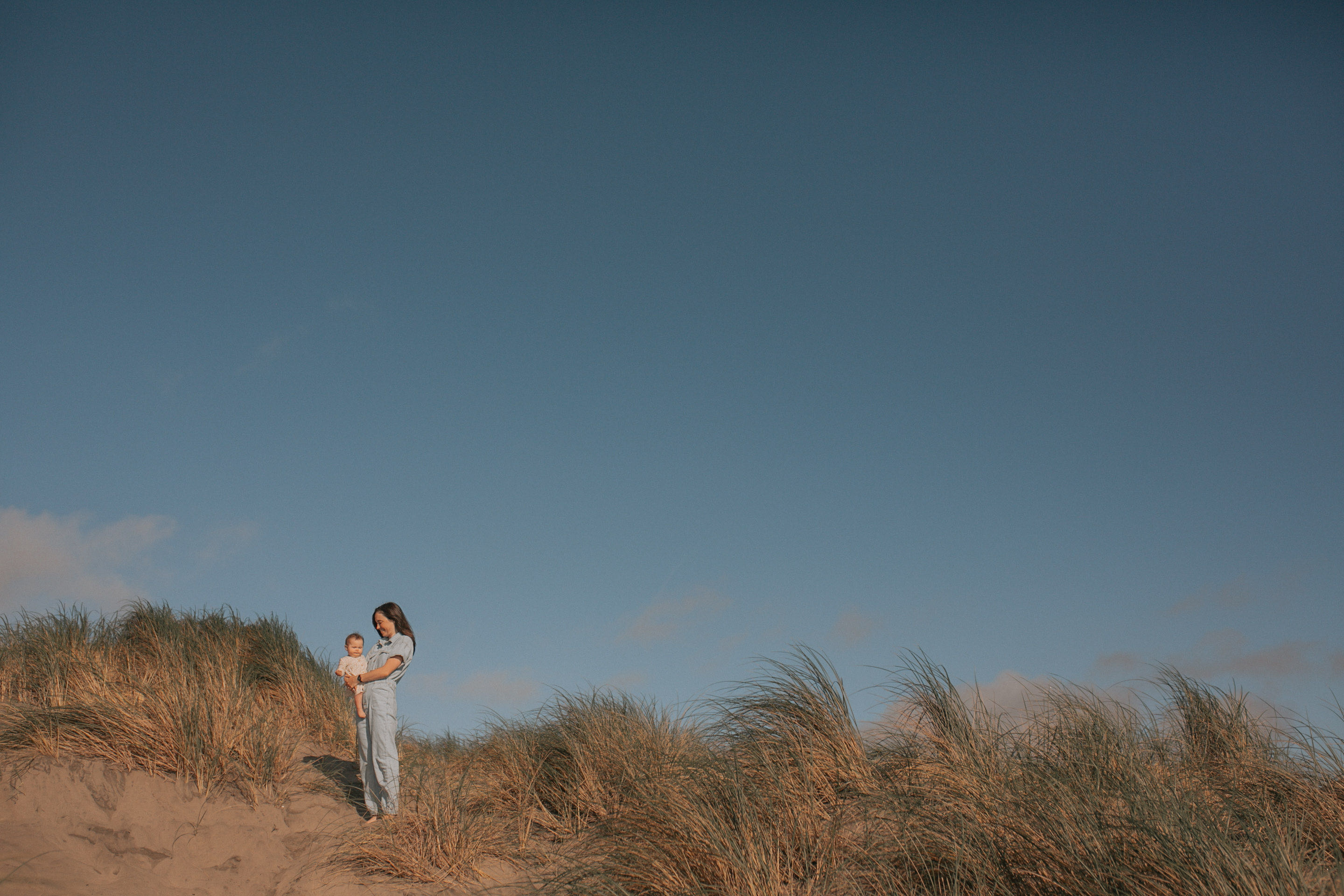 Sacha with her child on beach dunes